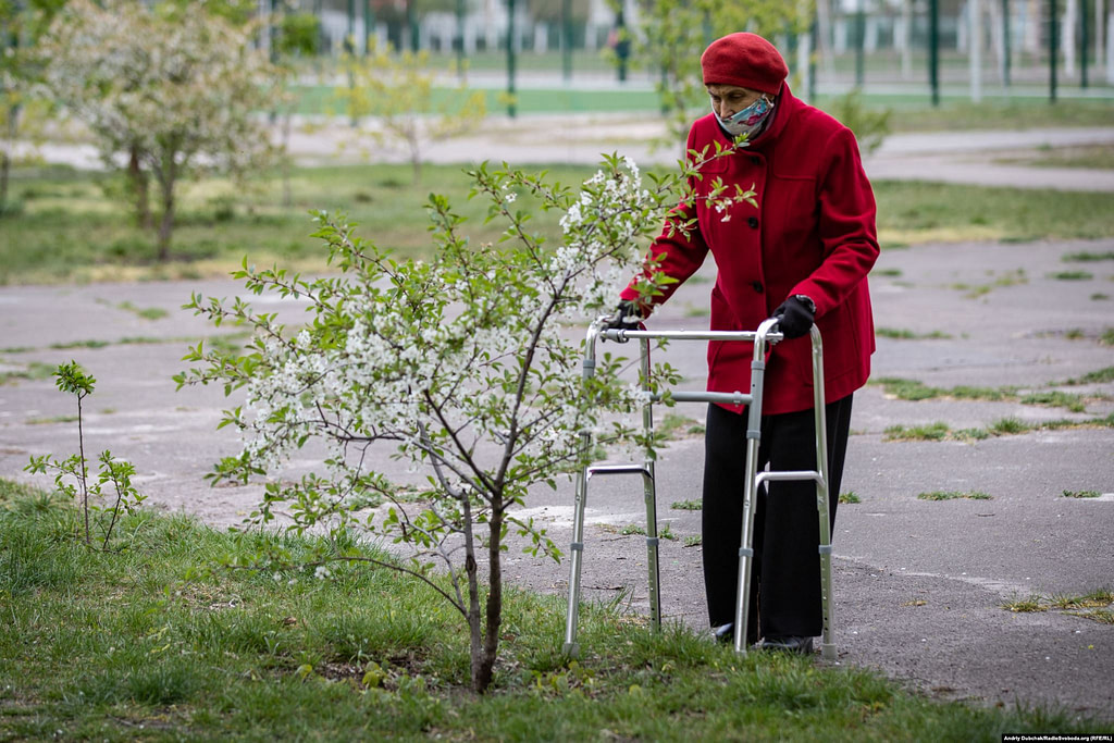 Літня жінка з ходунками біля вишні. Фото - Андрій Дубчак