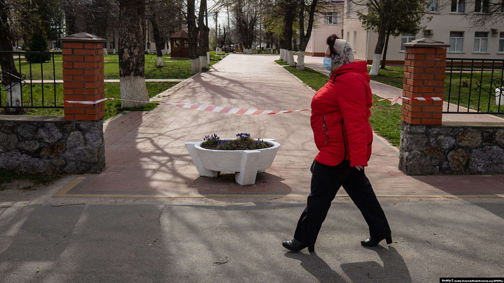 A woman walks past the entrance to the hospital in Kalynivka. Dubchak says the town of 20,000 people where he grew up has been transformed by the virus. Streets are largely empty and police in patrol cars use loudspeakers to urge people to stay indoors.  Photographer Andriy Dubchak / Ukraine
