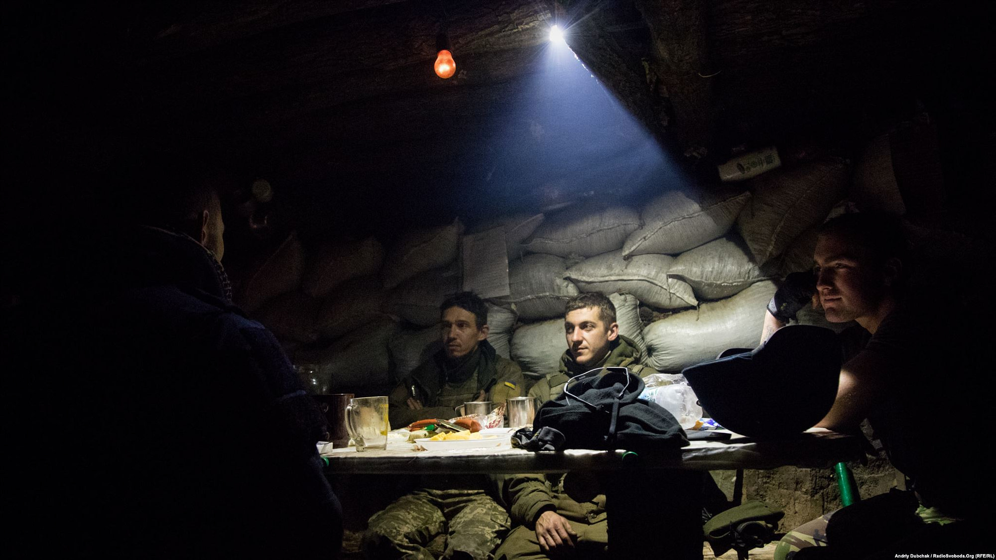 Dinner in the middle of fighting. Men drink tea and rest in a kitchen-dugout, while other soldiers were suppressing enemy fire. (photo by ukrainian military photographer Andriy Dubchak)
