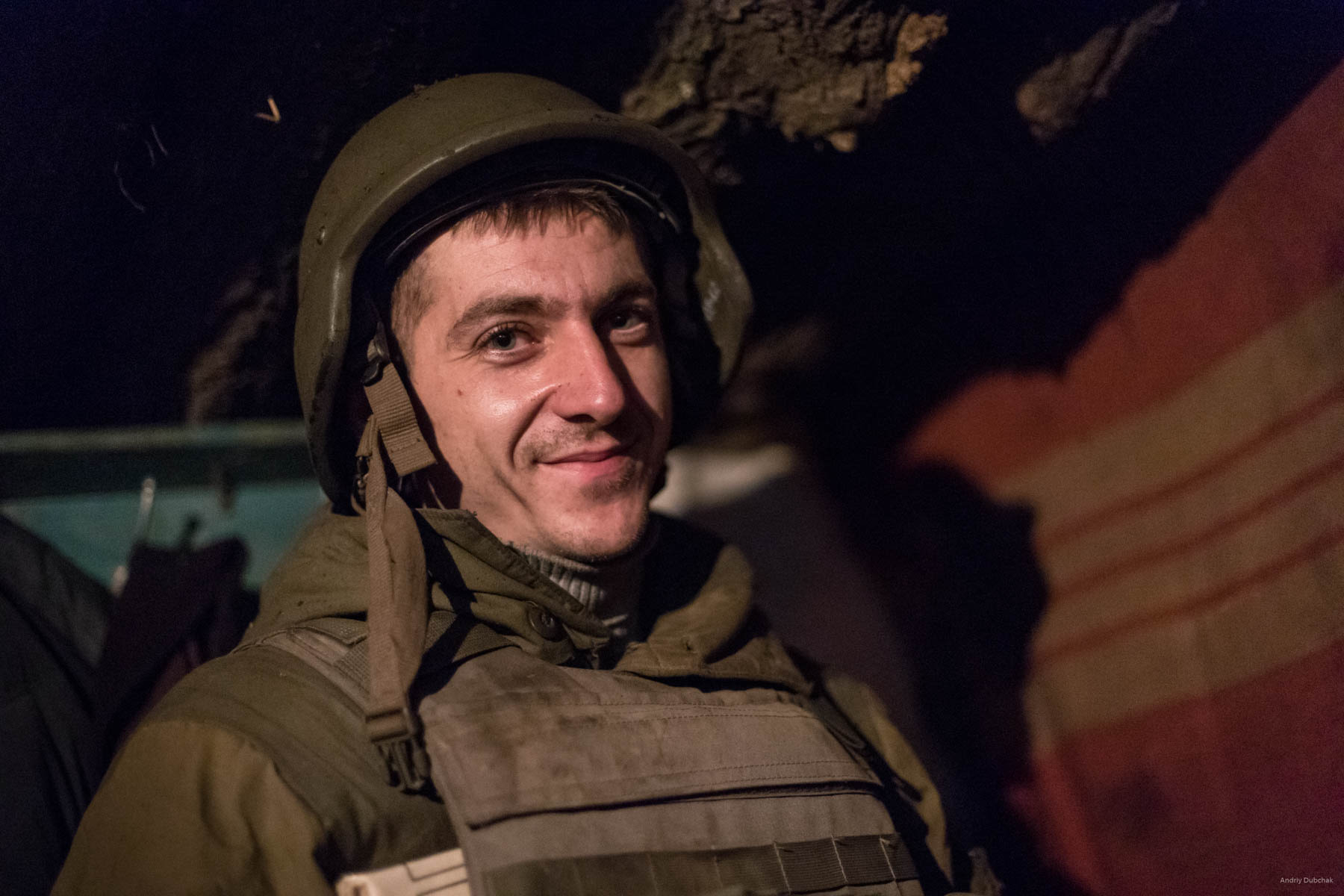 A fighter smiles, who came in for a moment to the dugout during a night battle, near Popasnaya, December 2017.