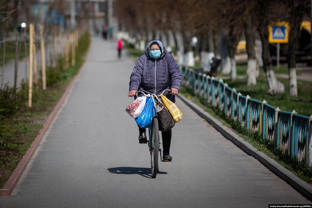 Жінка на велосипеді їде алеєю біля Машинобудівного заводу. Фото - Андрій Дубчак