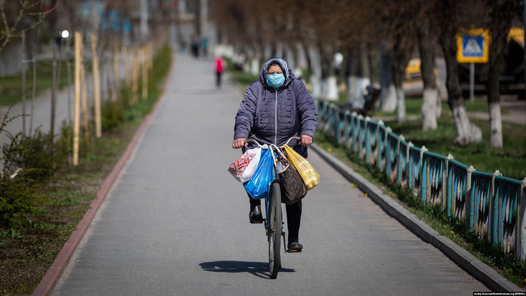 An elderly woman cycles through Kalynivka. All public transport in the town has been suspended.  Photographer Andriy Dubchak / Ukraine
