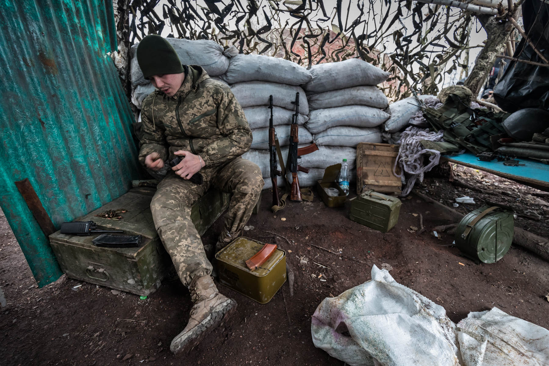 Alexander, a fighter from Kherson, reloads his assault rifle dispenser magazine on a position reinforced with refuse stone bags, on the gob pile near a town Zolote. - Do you want to go home? Sasha smiles: - I feel sad at home. In addition, here are our boys. It’s OK.  The guy is 20 years old. In a conversation, he often uses the phrase “It’s OK.”    District of Popasnoy, December 2017 