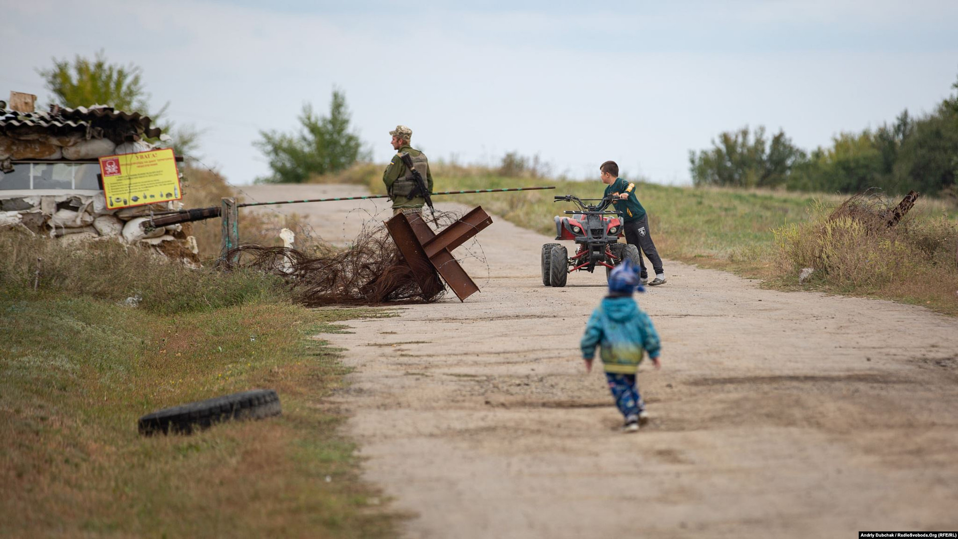 Ten-year-old Davyd rides a mini-quad bike while Stepan tries to catch up. Children are not permitted to go beyond the Luhanske checkpoint. (photo: Andriy Dubchak)